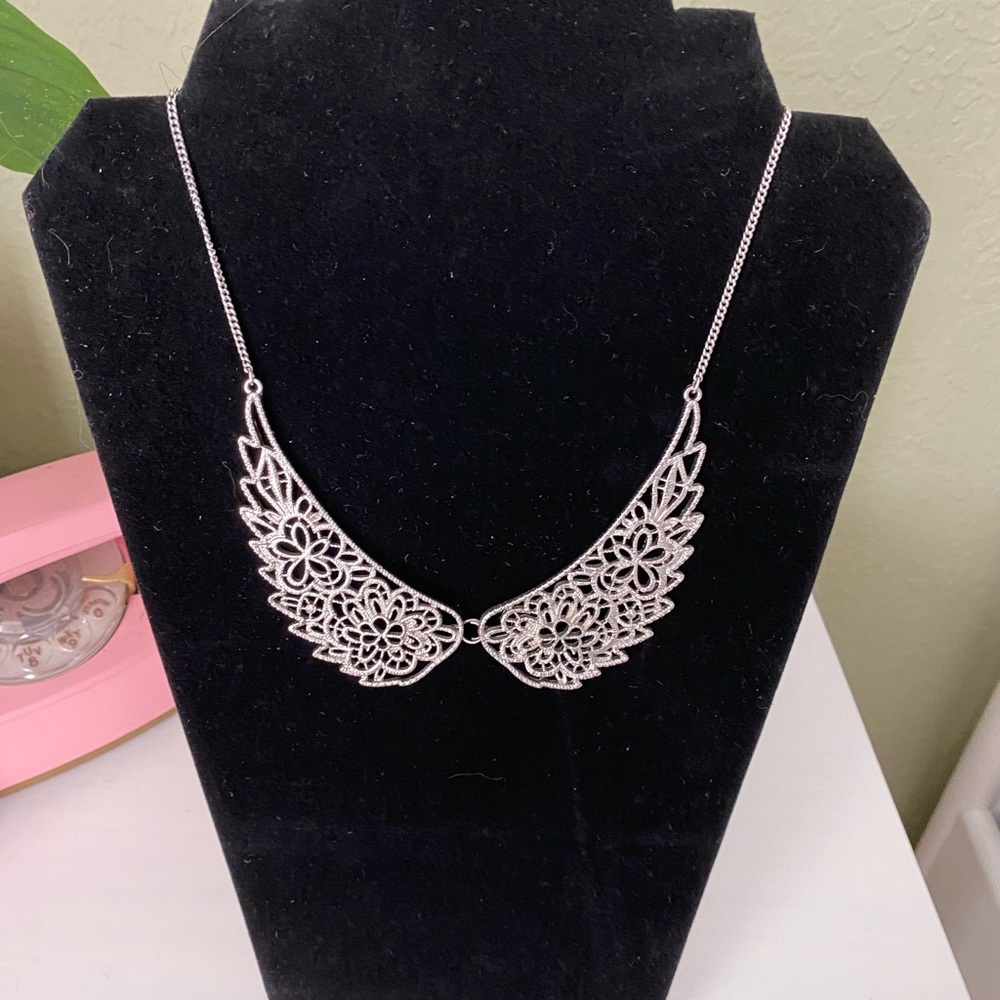 Silver tone wing necklace.